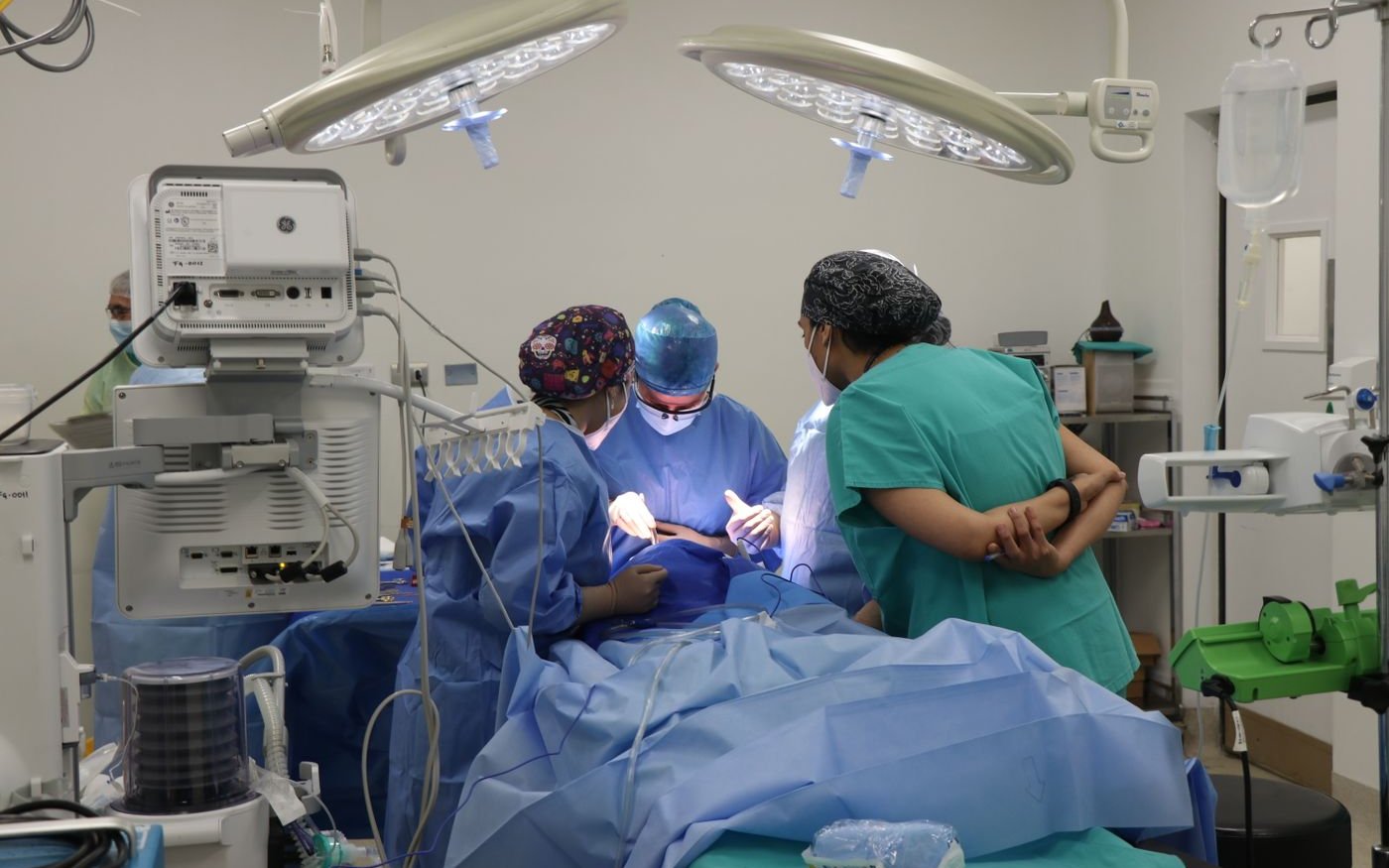 A team of surgeons operating in a well equipped room