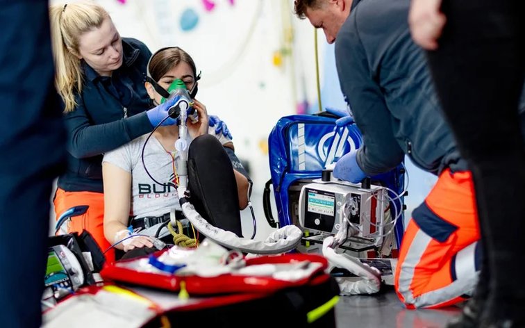 Equipo de atención prehospitalaria asistiendo a una paciente con monitor y maletines